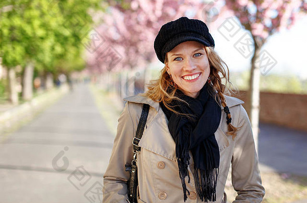 快乐年轻的女人露出牙齿的微笑早期春天公园