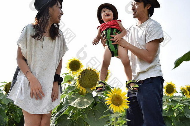 年轻的家庭微笑向日葵场