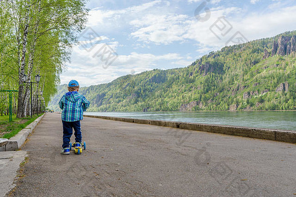 一年男孩滑冰踏板车山公园