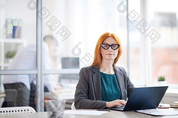 肖像成人红色的头发的女商人相机移动PC工作场所办公室复制空间