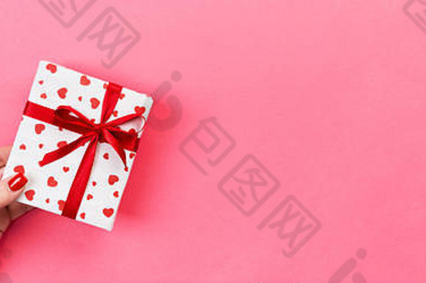 女人手给包装情人节假期手工制作的现在纸红色的丝带现在盒子红色的心装饰礼物粉红色的表格