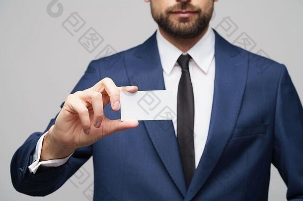 工作室照片年轻的英俊的商人穿西装持有业务卡