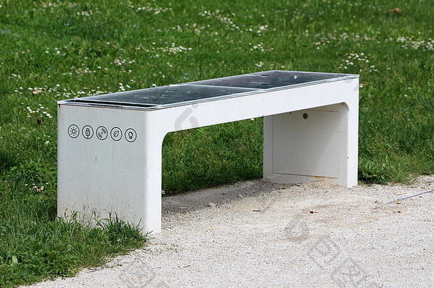 聪明的公共公园板凳上摧毁了太阳能面板权力电池充电移动手机闪电砾石路径