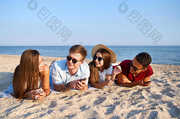 年轻的多民族集团<strong>黄金时代</strong>放松海滩毛巾海白色沙子时尚的朋友挂海岸会说话的日光浴