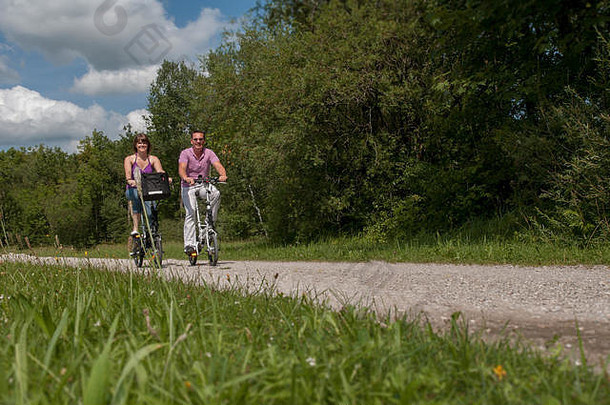 年轻的快乐夫妇骑自行车自然现代电动自行车