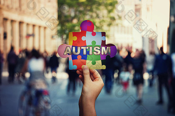 象征自闭症孩子手持有色彩斑斓的谜题一块拥挤的街背景社会意识自闭症教育
