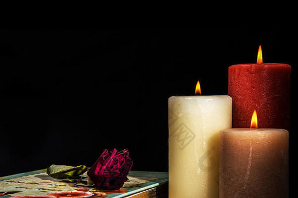 枯萎的褪了色的红色的玫瑰书日记燃烧蜡烛黑色的背景假期浪漫的概念房间文本
