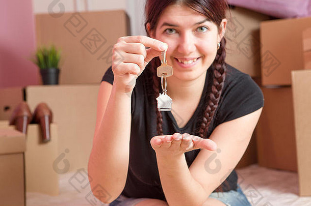 图像年轻的浅黑肤色的女人键公寓空白墙