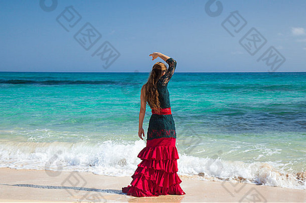 年轻的有吸引力的女人红色的绿色弗拉曼柯舞衣服海洋海岸