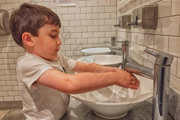 年轻的男孩洗手水槽公共厕所。。。