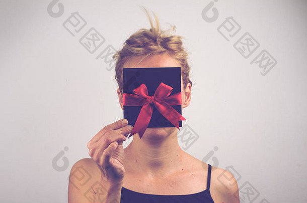 肖像年轻的高加索人女人持有黑色的礼物卡红色的丝带前面脸