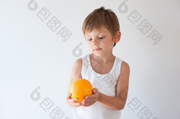 美丽的小健康的高加索人孩子持有橙色看明亮的背景
