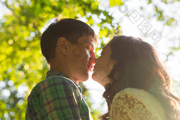 特写镜头照片浪漫的接吻夫妇在户外一边视图