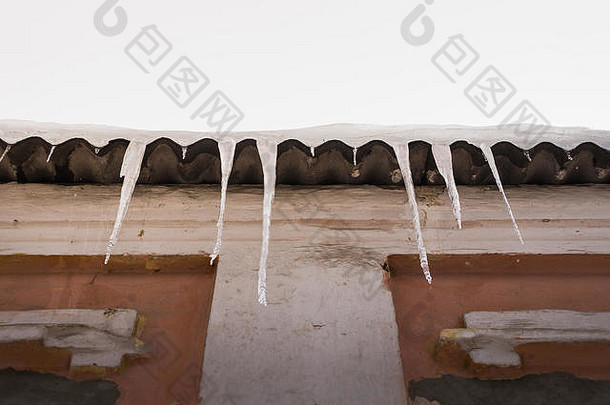 巨大的危险的冷冰冰的人形成屋顶危险冰融化挂屋顶建筑冬天