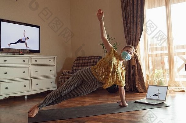 运动年轻的女人采取瑜伽教训在线实践首页检疫概念健康的生活方式健康安全冠状病毒流感大流行爱好