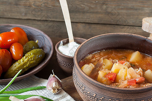 传统的乌克兰蔬菜汤罗宋汤腌制西红柿黄瓜酸奶油切片面包草本植物大蒜