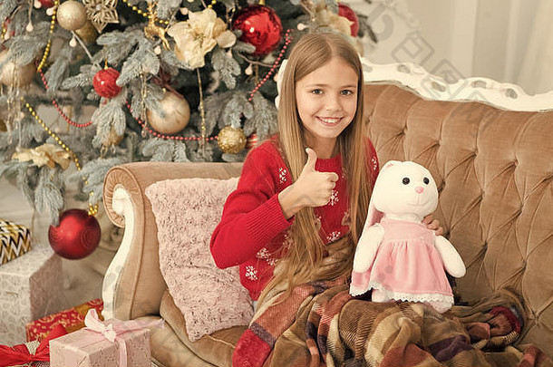 女孩拇指可爱的兔子圣诞节树小女孩持有兔子<strong>玩具</strong>孩子玩软<strong>玩具</strong>小孩子快乐微笑现在圣诞节<strong>玩具</strong>