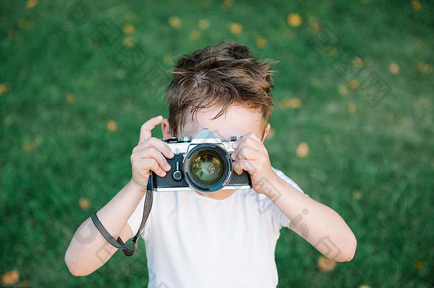 有趣的可爱的孩子图片古董电影相机绿色草背景下降叶子