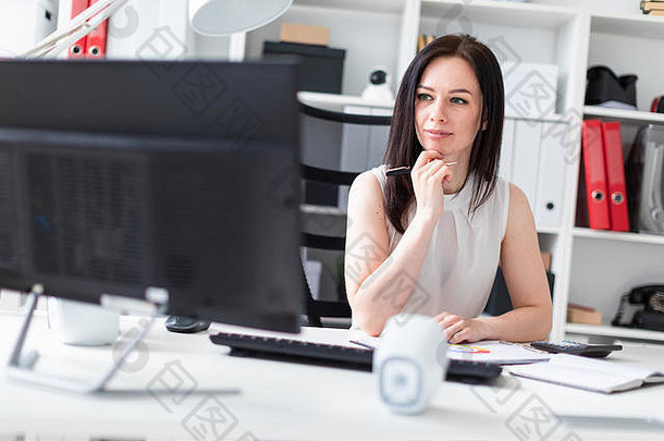 年轻的女孩坐着办公室电脑桌子上工作文档计算器