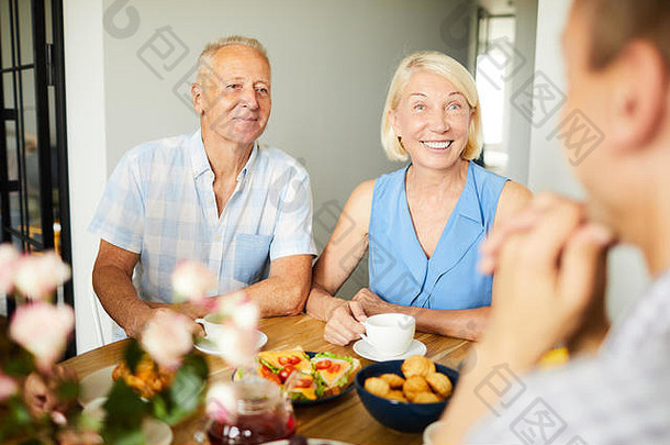 肖像微笑成熟的夫妇坐着晚餐表格朋友家庭复制空间