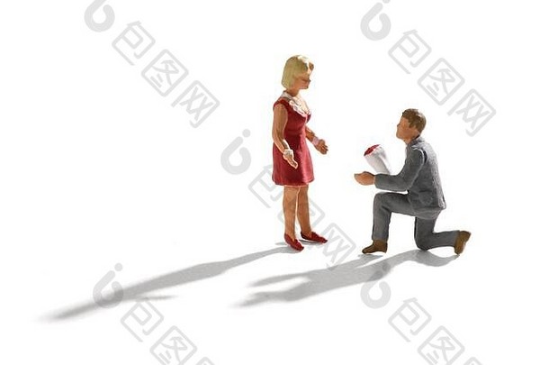 微型场景订婚建议小男人。灰色西装膝盖花束花提出女人红色的衣服