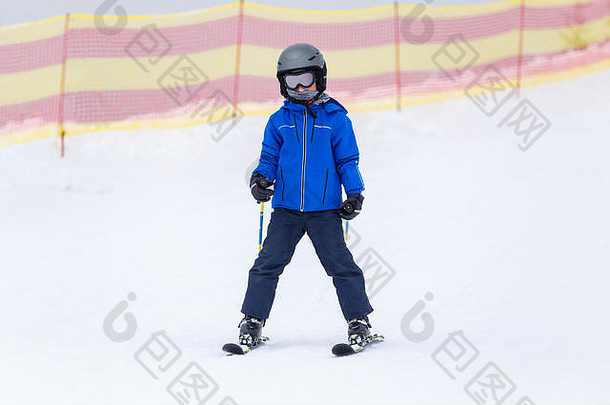 小男孩头盔滑雪坡山滑雪度假胜地