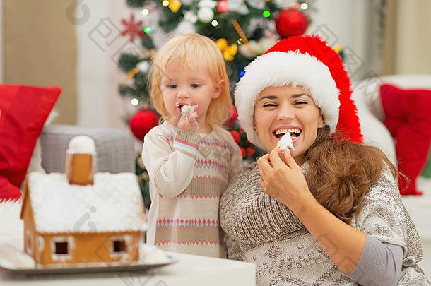 快乐妈妈。婴儿吃圣诞节饼干
