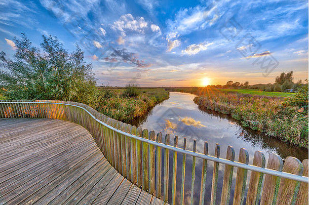 生动的日落木栏杆阳台桥onlanden自然储备洪涝灾害区域格罗宁根荷兰