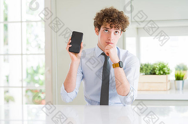 年轻的业务男人。显示智能手机屏幕办公室脸思考问题困惑的想法