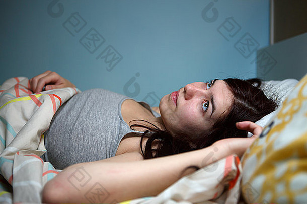 年轻的女人说谎床上痛苦失眠嘈杂的邻居压力报警声音防止睡眠概念