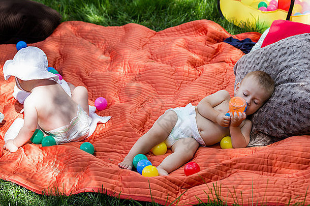 可爱的婴儿玩毯子后院