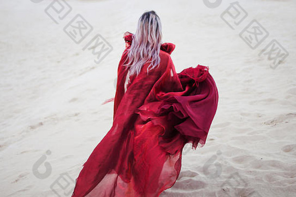 女人红色的运行女孩令人惊异的朱红色衣服在户外沙漠回来视图