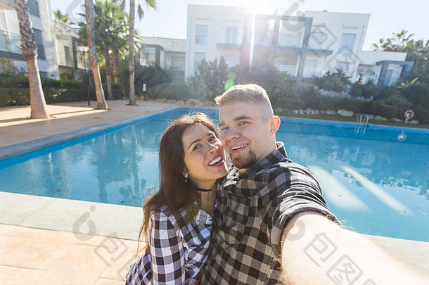 旅行假期假期概念年轻的夫妇自拍智能手机照片游泳池