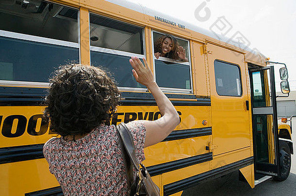 妈妈。挥舞着十几岁的女儿学校公共汽车