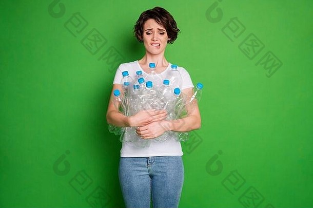 照片美丽的夫人持有塑料瓶携带垃圾回收服务不负责任的人人类人类咬嘴唇困惑穿白色t恤