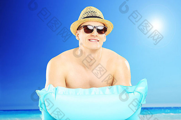 英俊的的家伙他太阳镜说谎游泳床垫海滩