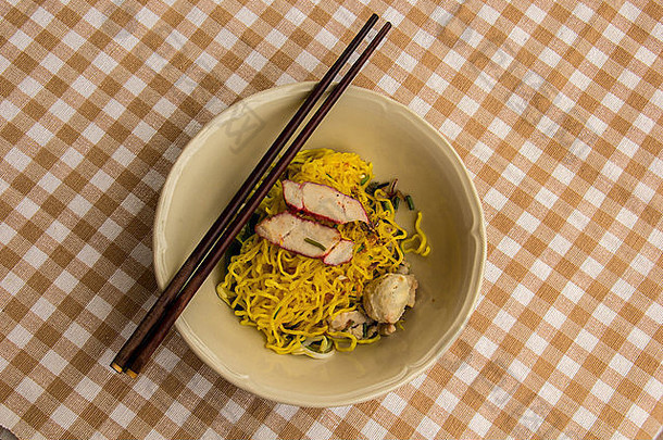 黄色的面条碗猪肉菜筷子香菜