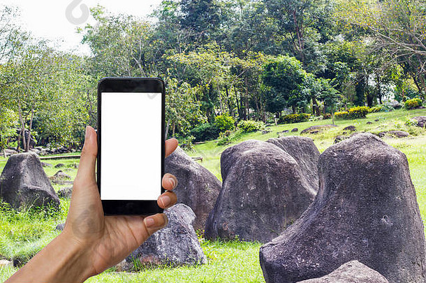 手持有黑色的智能手机白色屏幕模拟石头花园背景